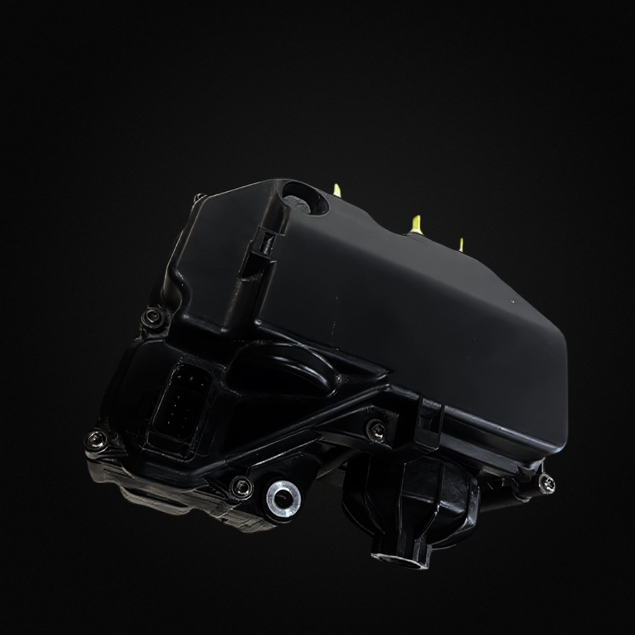 Close-up of a black, rectangular electronic device or component with screws, a connector port, and a cylindrical part against a black background.