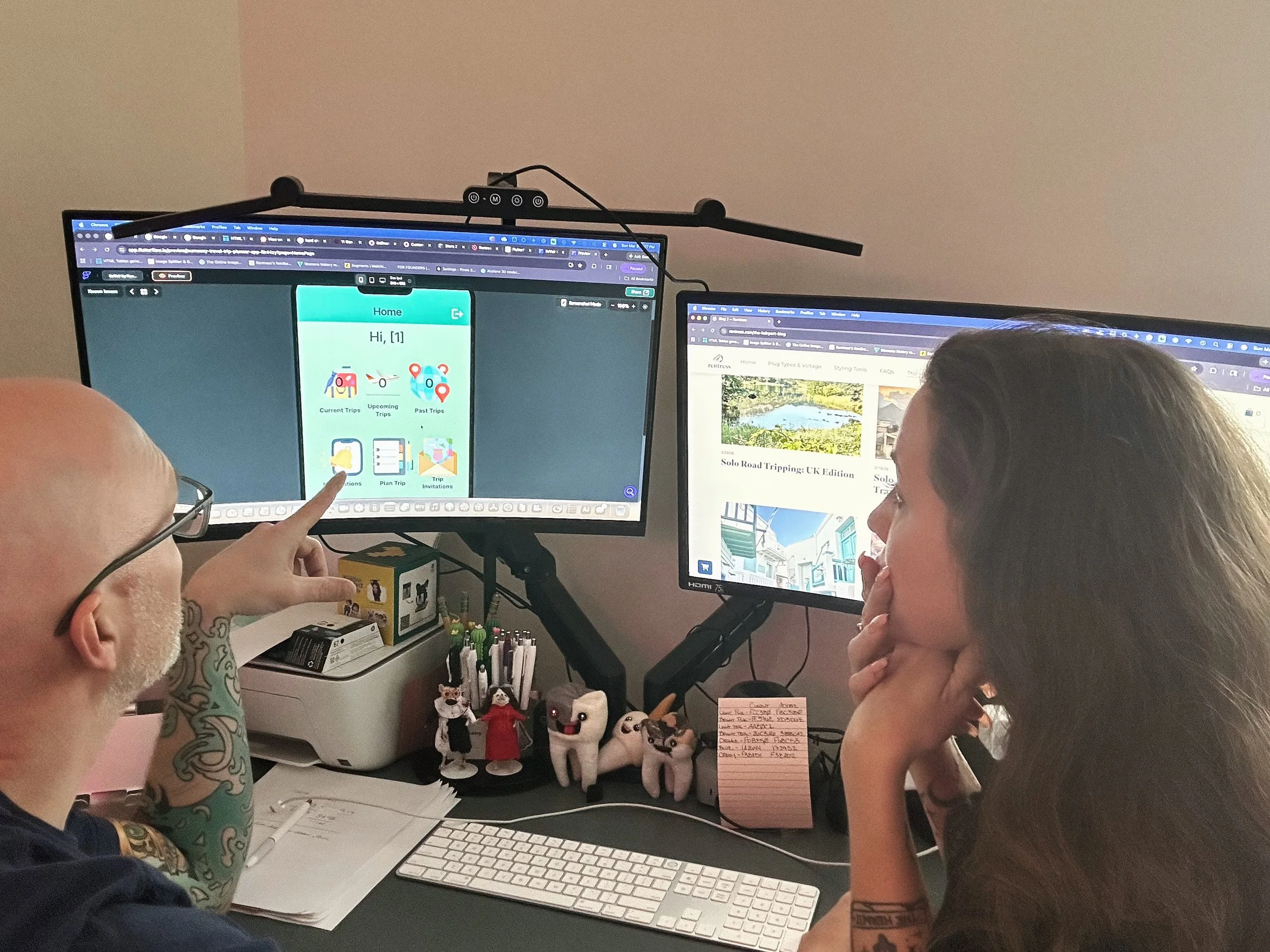 A man and a woman looking at a travel app on a computer screen.