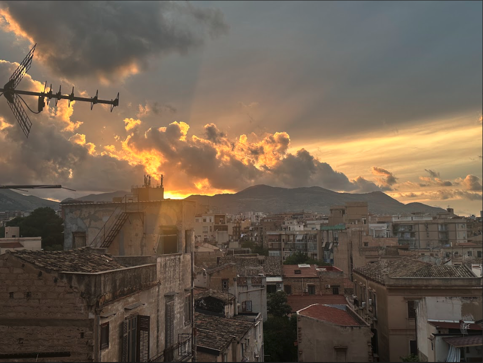 A beautiful sunset over an old city. There is a mountain in the background.