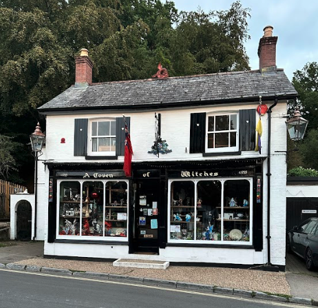 A black and white building with signage reading "A Coven of Witches".