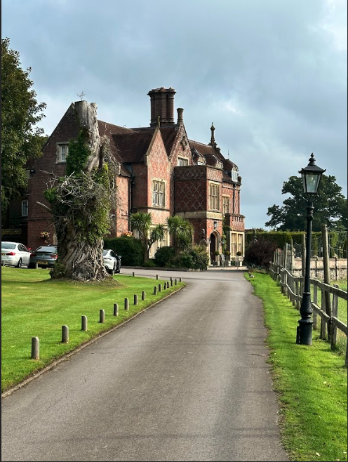 A beautiful old Victorian manor home, with red brick and large chimney.
