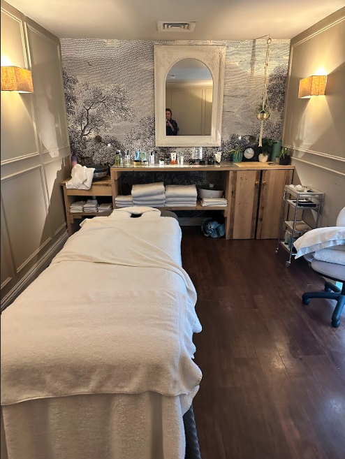 A spa treatment room with a massage table and soft lighting.