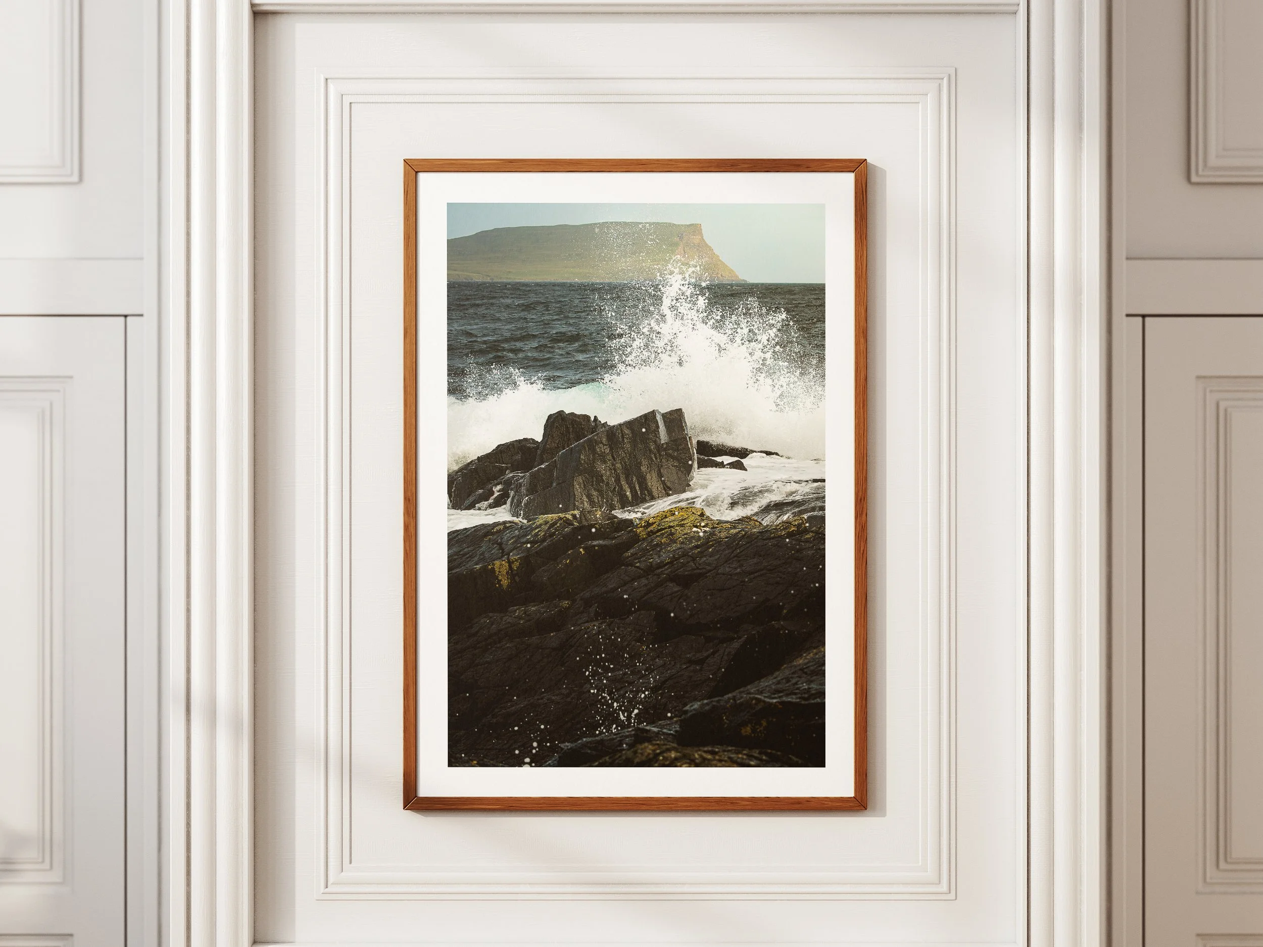 A framed Picture of a wave crashing over the rocks