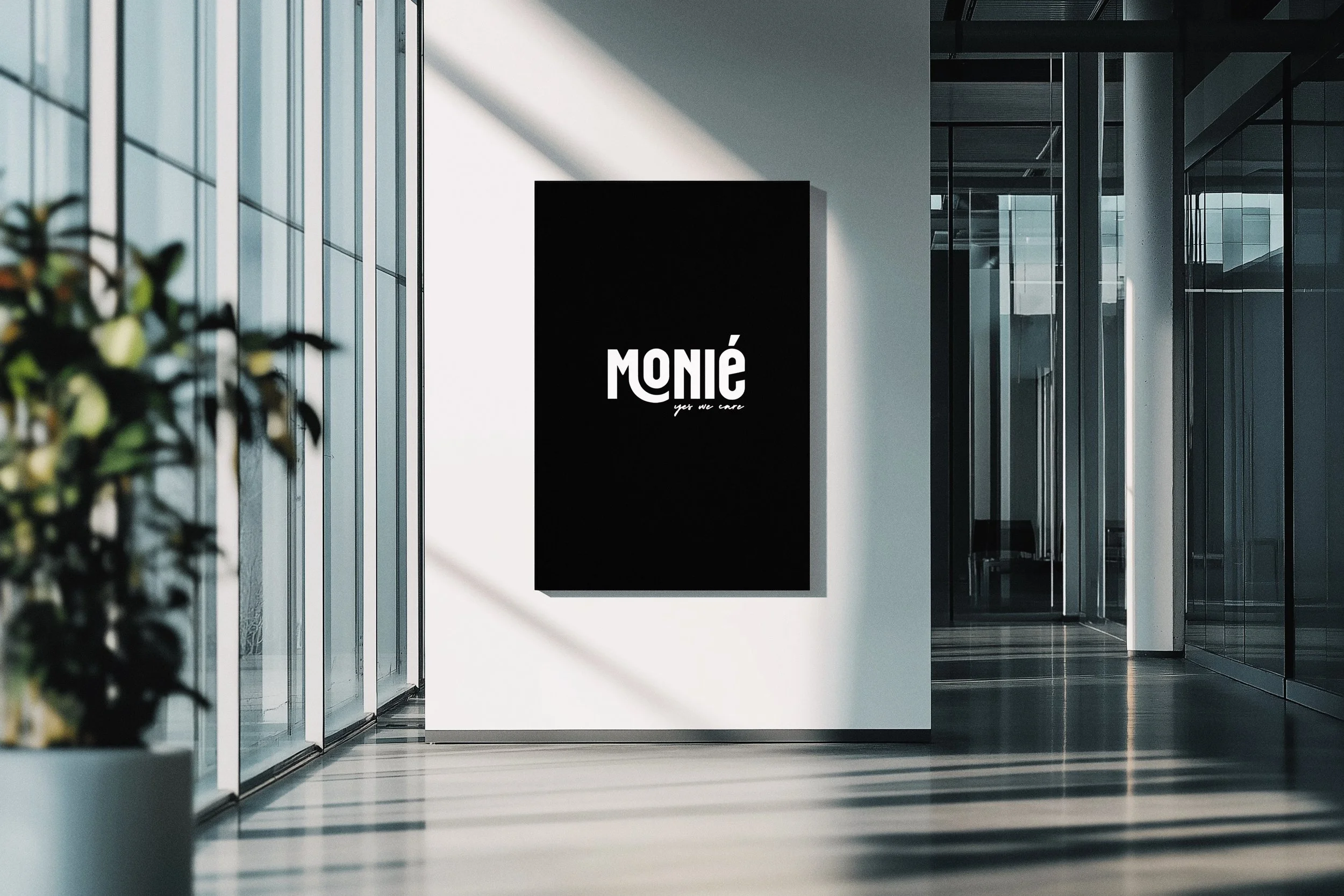 Modern office interior with glass walls and a large black display board labeled 'Moné' with the tagline 'yet we care' on a white wall.