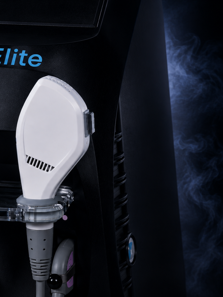 Close-up of a black equipment unit with a white handheld device attached, with blue text "Elite" on the black surface, emitting steam or vapor in a dark background.