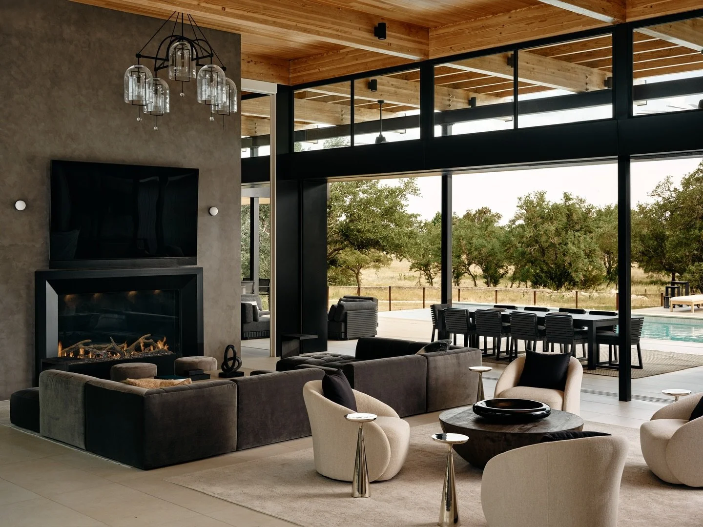 Seamless luxury for all seasons. At the Driftwood Residence, floor-to-ceiling sliding glass doors open the living room to the hillside, with a cozy fireplace at the center.

Architect: @hudginsdesign 
Builder: @builders___workshop 

#titoni #luxurywi