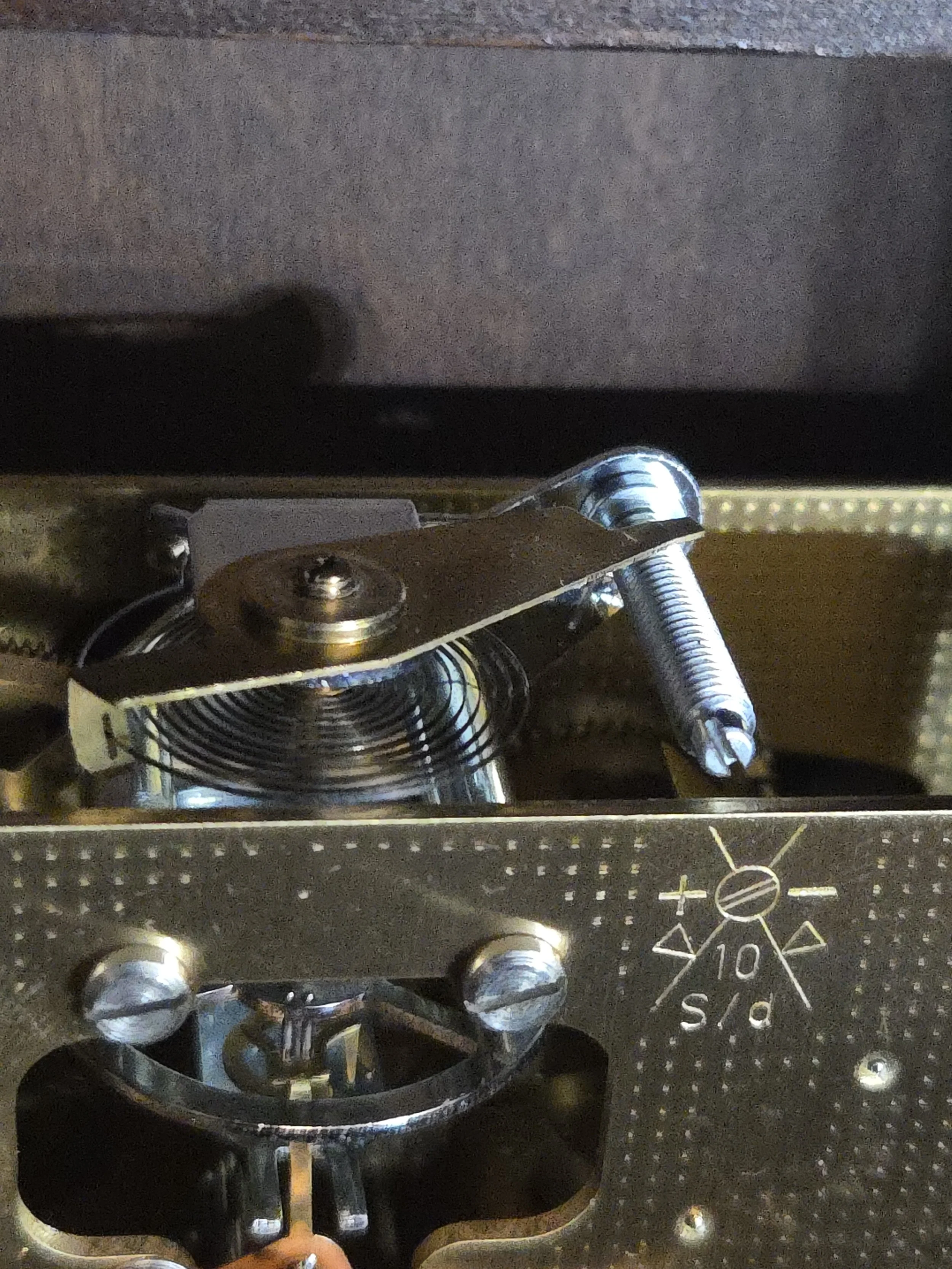 Close-up of a mechanical timer and control knob inside a metallic appliance, likely a toaster or oven, with markings and a diagram on the side.