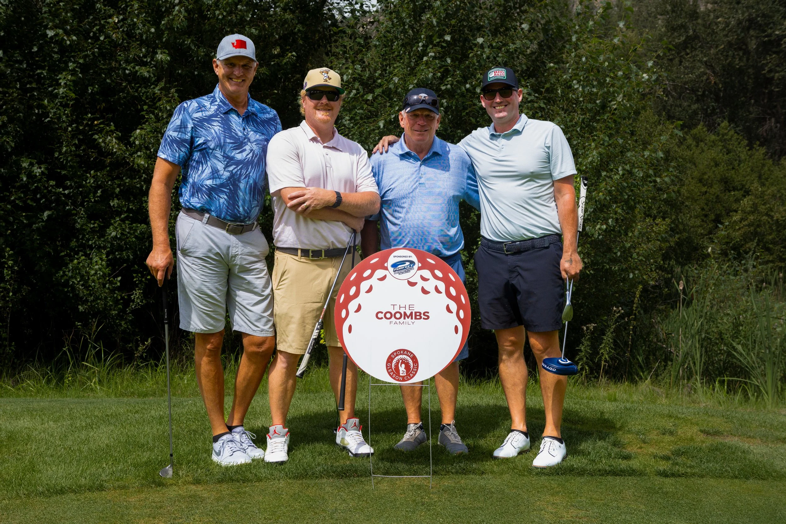 4 people standing behind a sign
