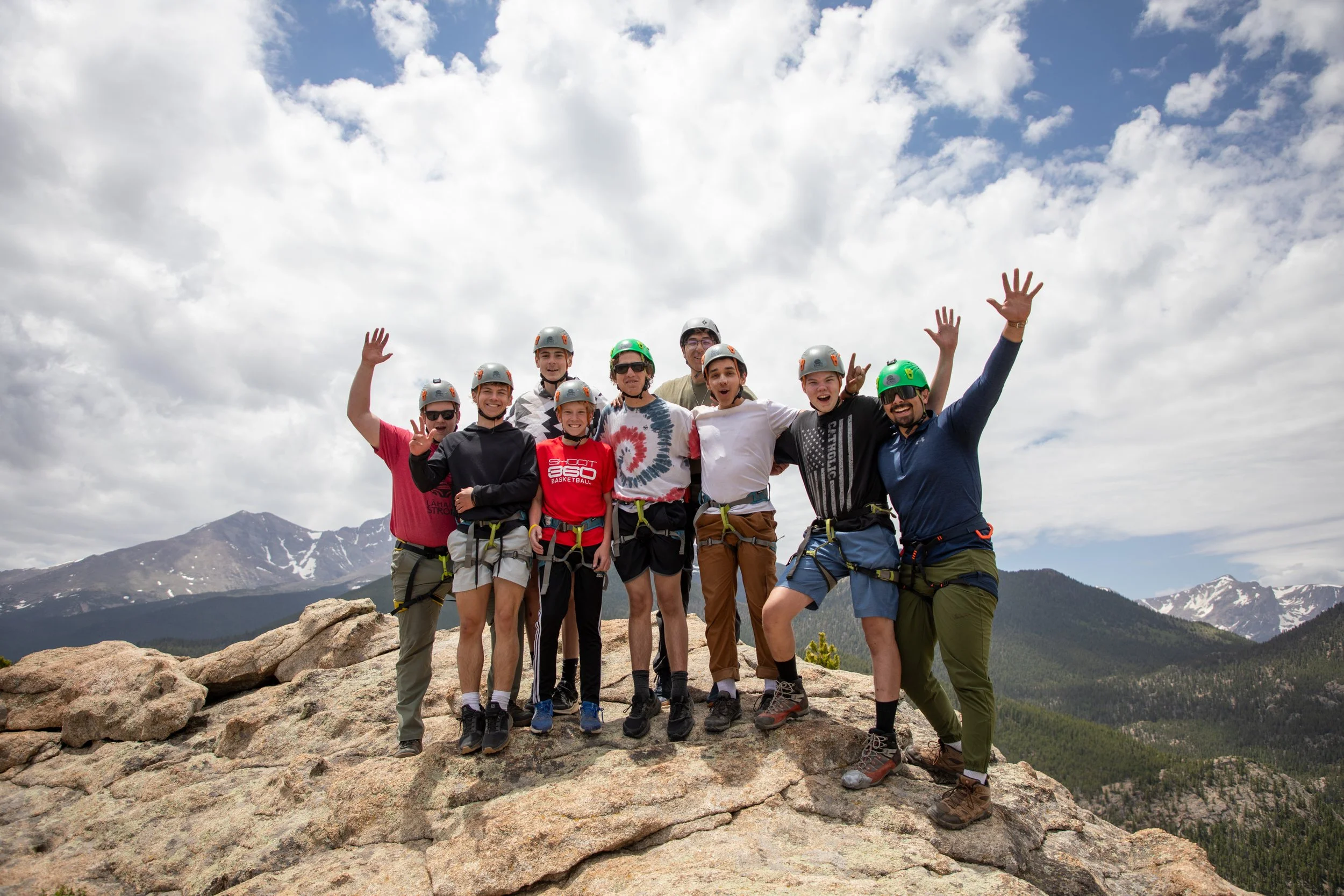 group of high school guys rock climbing in the Colorado Rocky Mountains while at a catholic summer camp