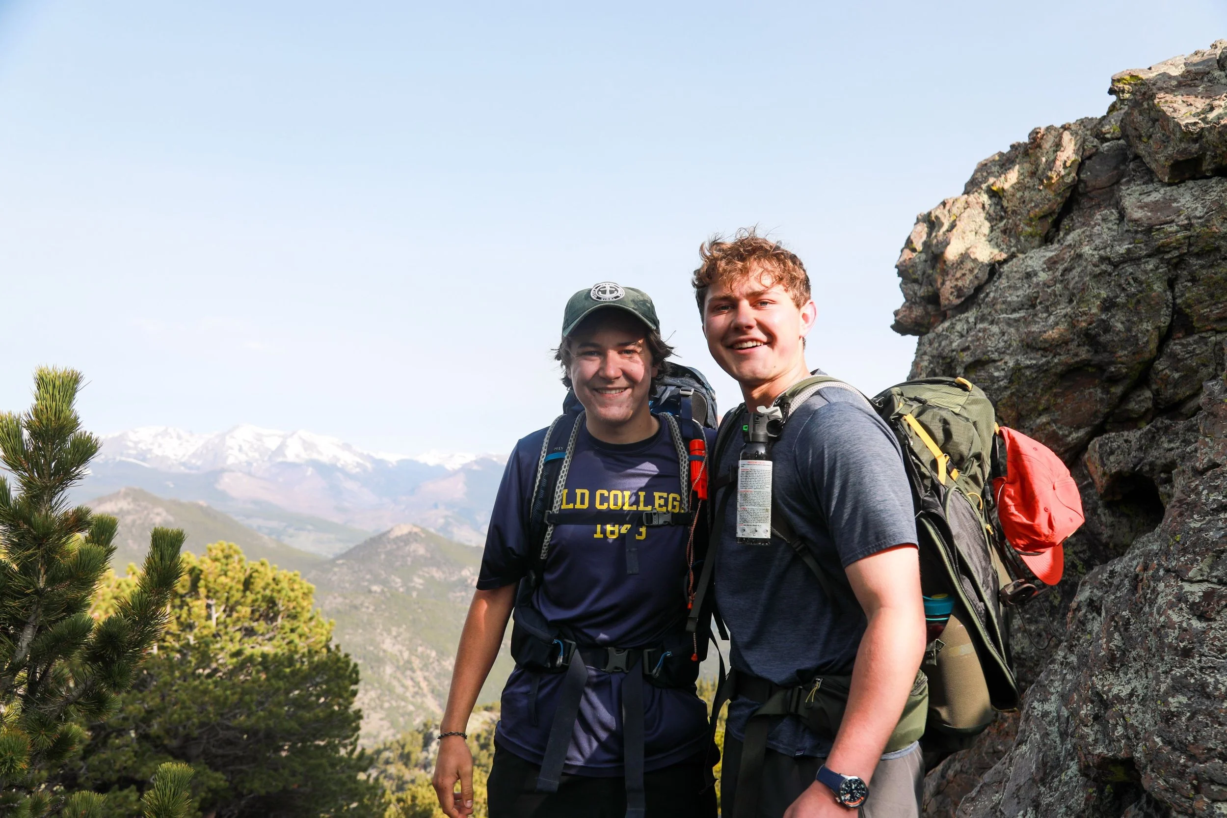 two college guys hiking in rocky mountains as counselors at a catholic camp in colorado