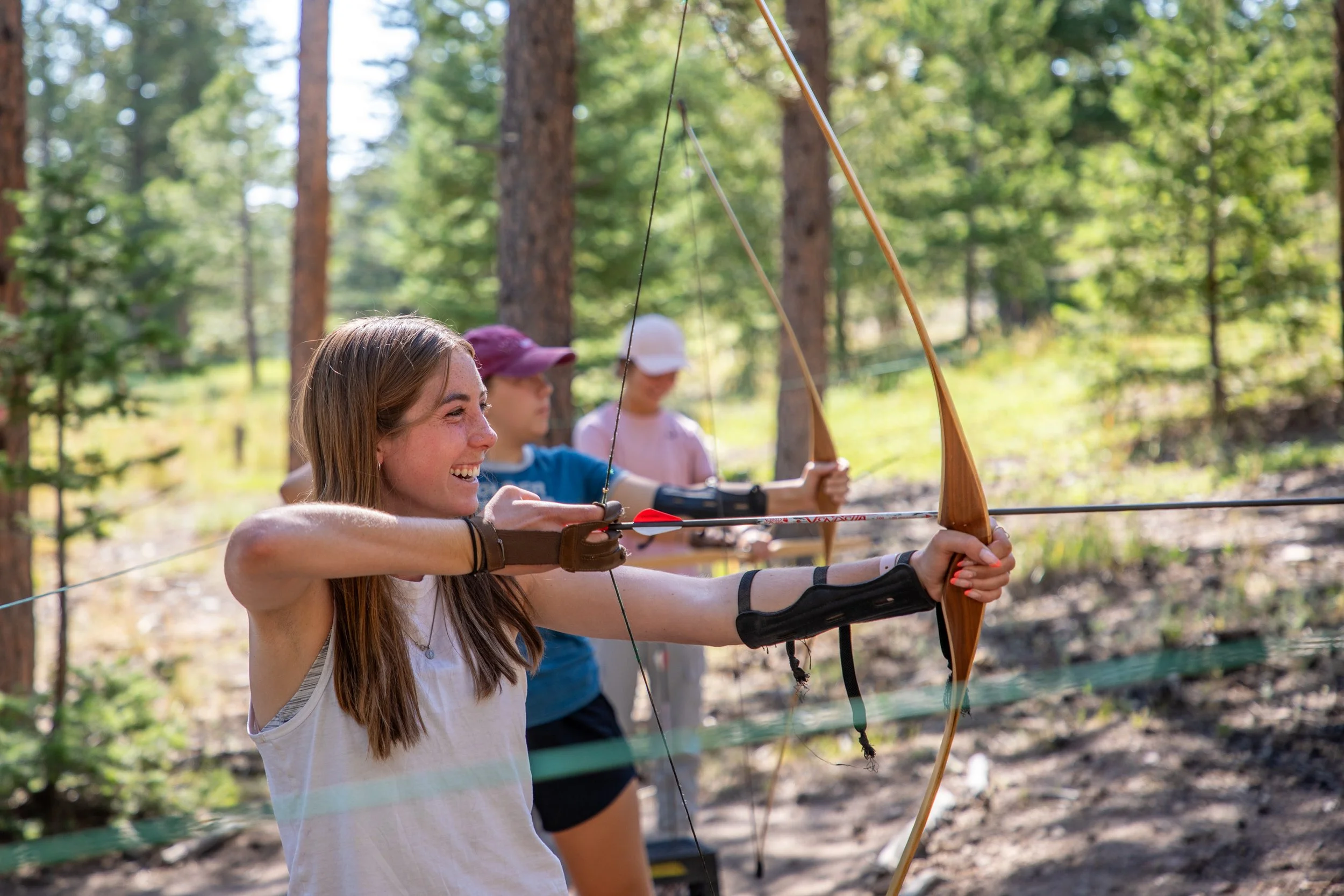 high school girl shooting archery at a Catholic summer camp in Colorado
