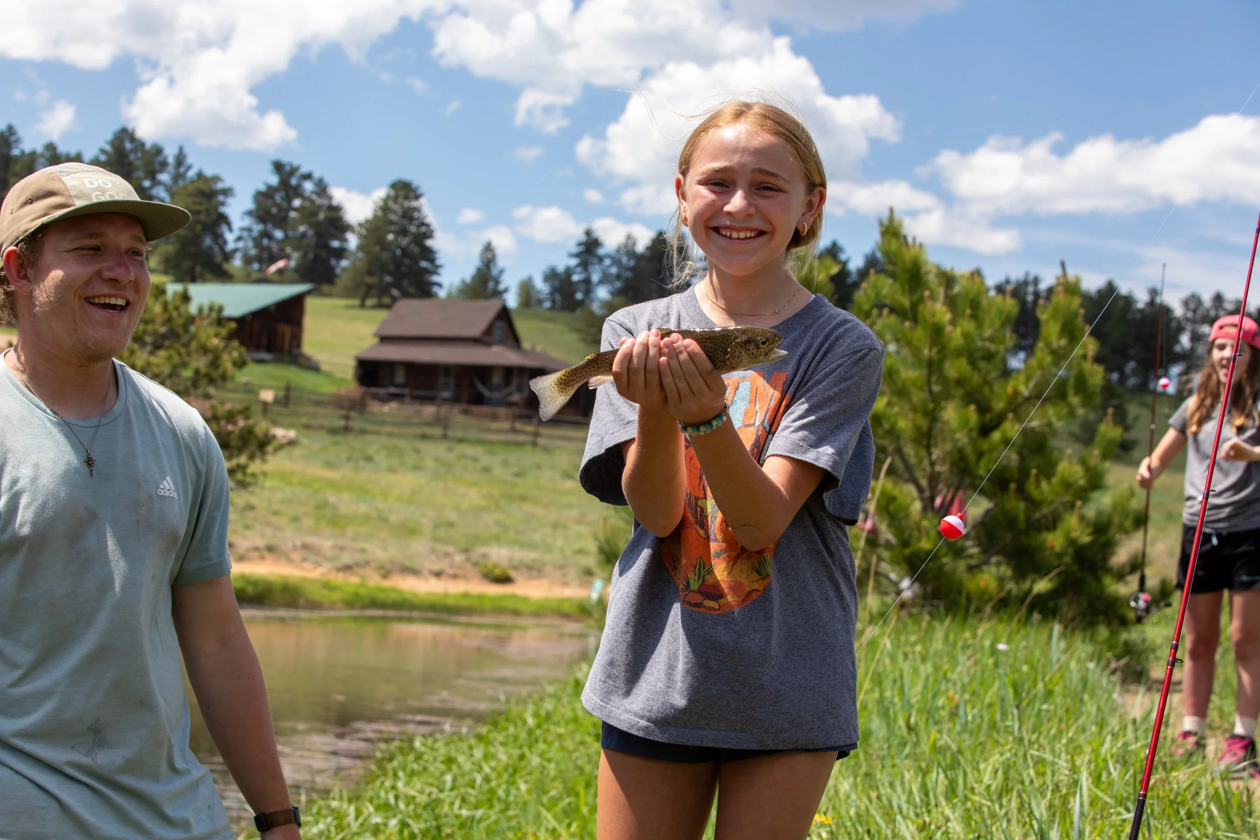 middle school girl holding a fish she just caught