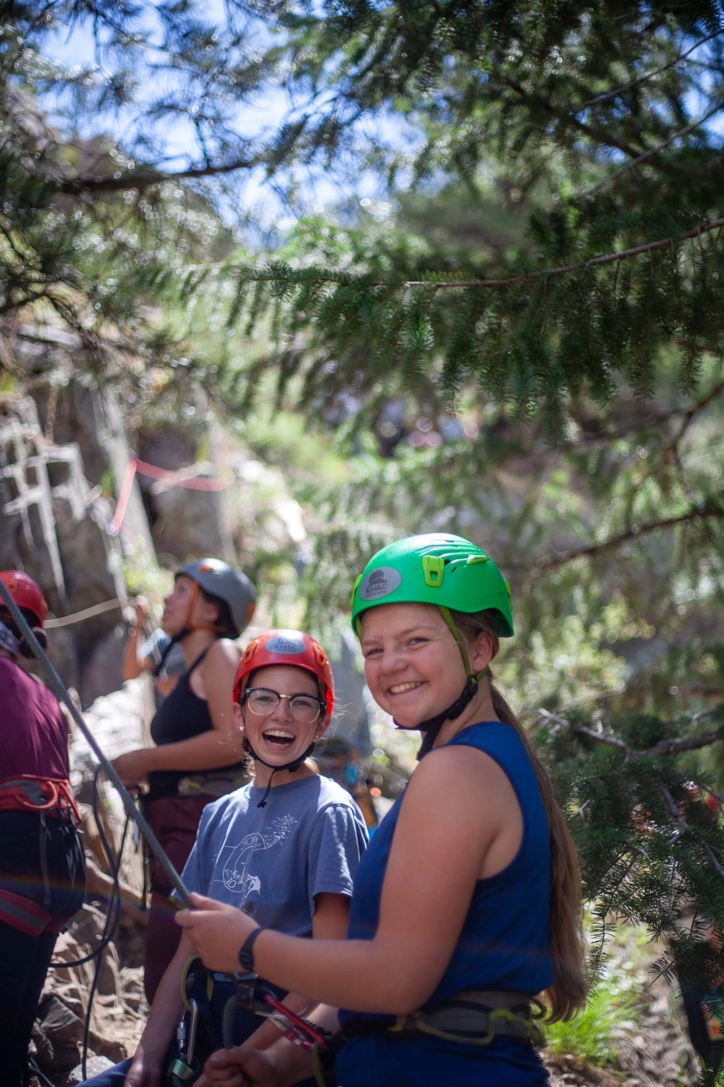 two high school girls rock climbing at a Catholic summer camp in Colorado
