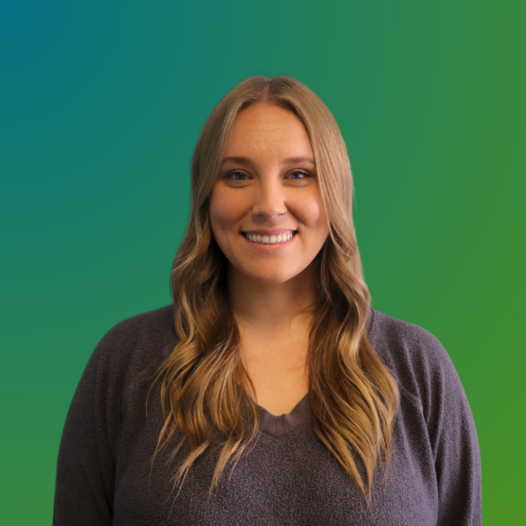 Young woman with long wavy blonde hair smiling against a solid teal background.