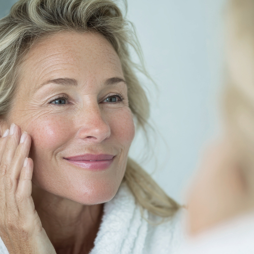 woman smiling in mirror at radiant skin