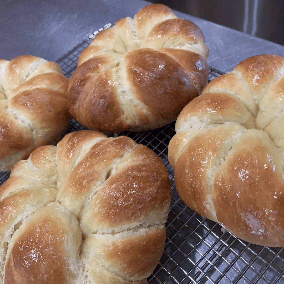 Freshly baked croissants on a cooling rack.