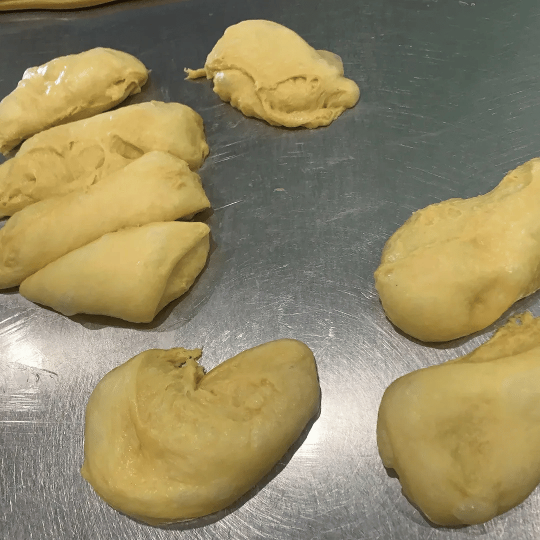 Uncooked durian fruit pieces on a metal surface.