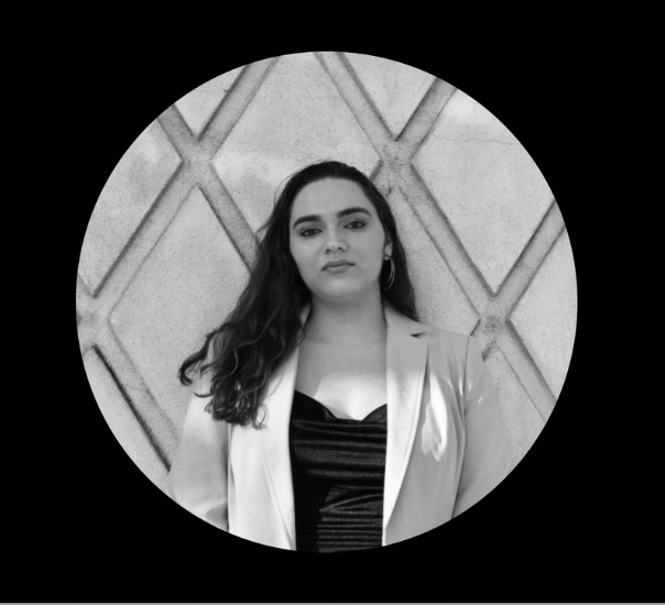 A black and white logo featuring two women's faces with wavy hair, a shield, and various decorative elements including a banner with Latin text.