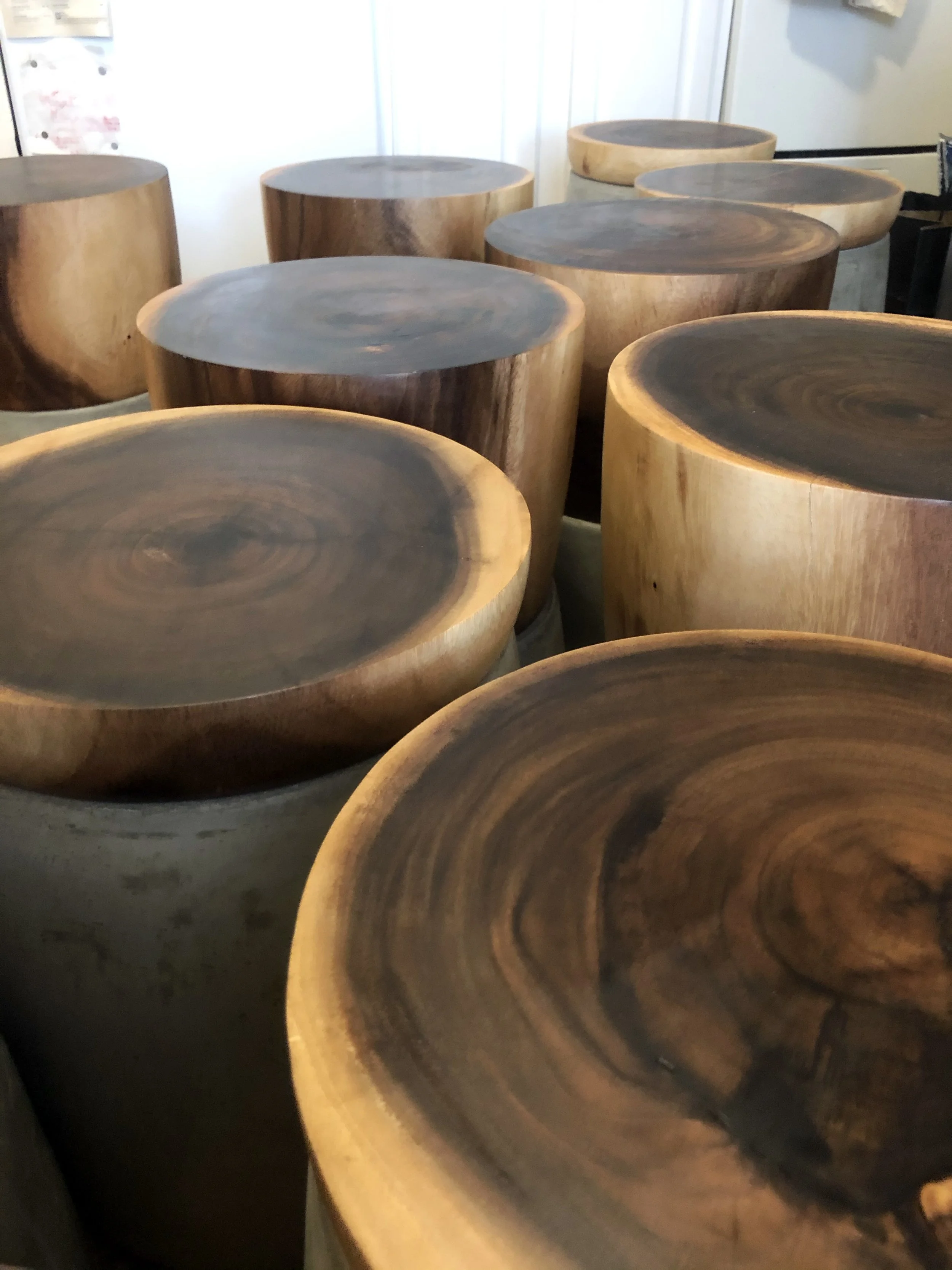 Stacked wooden logs with polished, dark tops and honey-colored sides.