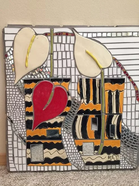 Decorative mosaic artwork featuring two yellow pear shapes, an apple with red and black stripes, and abstract patterns in black, white, orange, and beige.