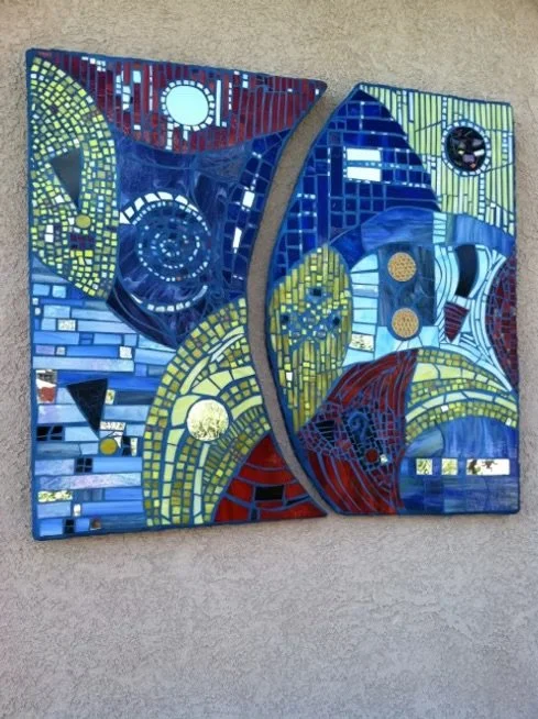 Two abstract mosaic panels with geometric shapes and vibrant colors mounted on a wall.