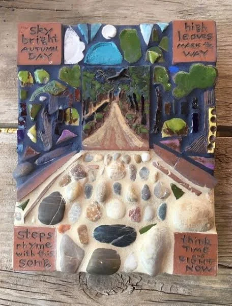 A miniature collage artwork depicting a nature scene with a pathway surrounded by trees under a sky, with handwritten quotes on orange paper in the corners. The quotes are: 'sky brightens autumn day,' 'high leaves reach the way,' 'steps pry me with t