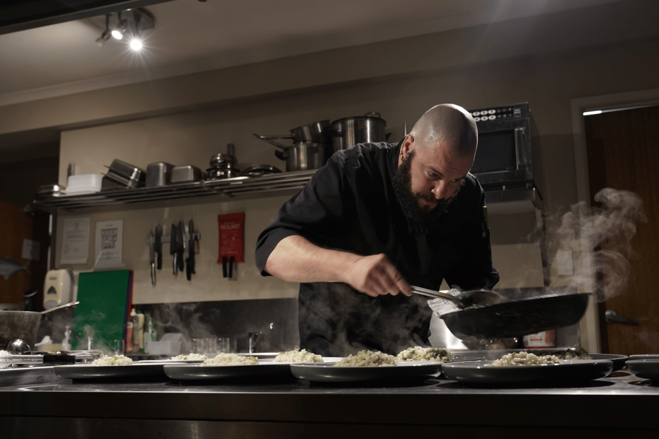 Chef plating food in a professional kitchen.
