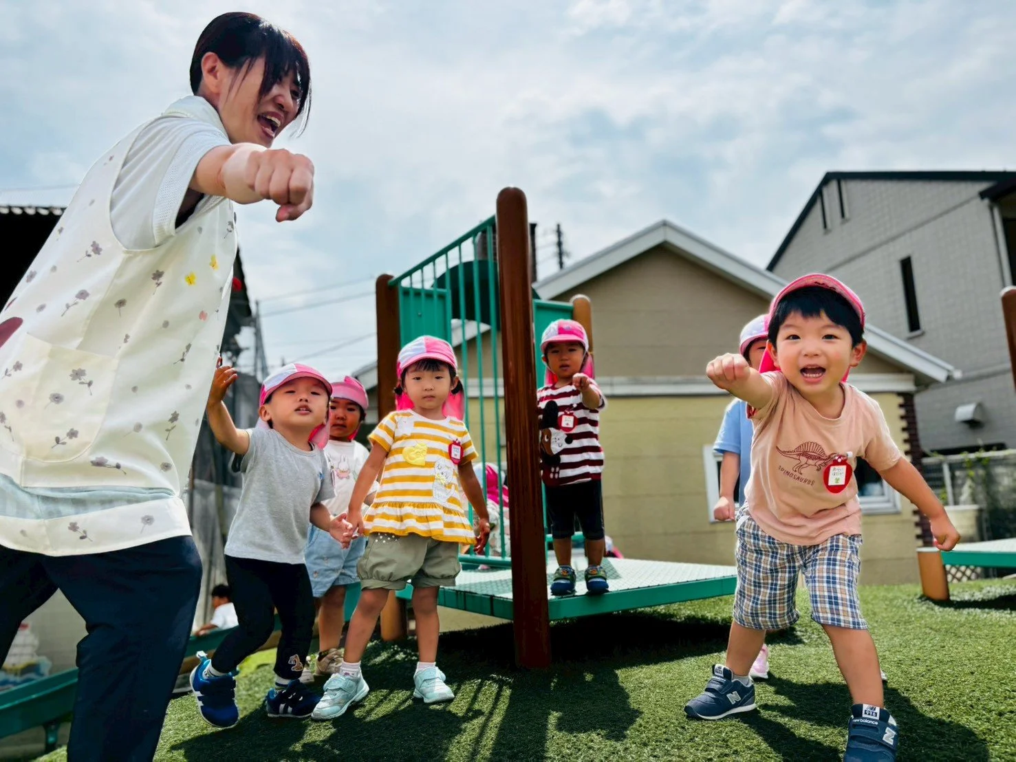 幼稚園児と先生が遊びながら運動している外の園庭の様子
