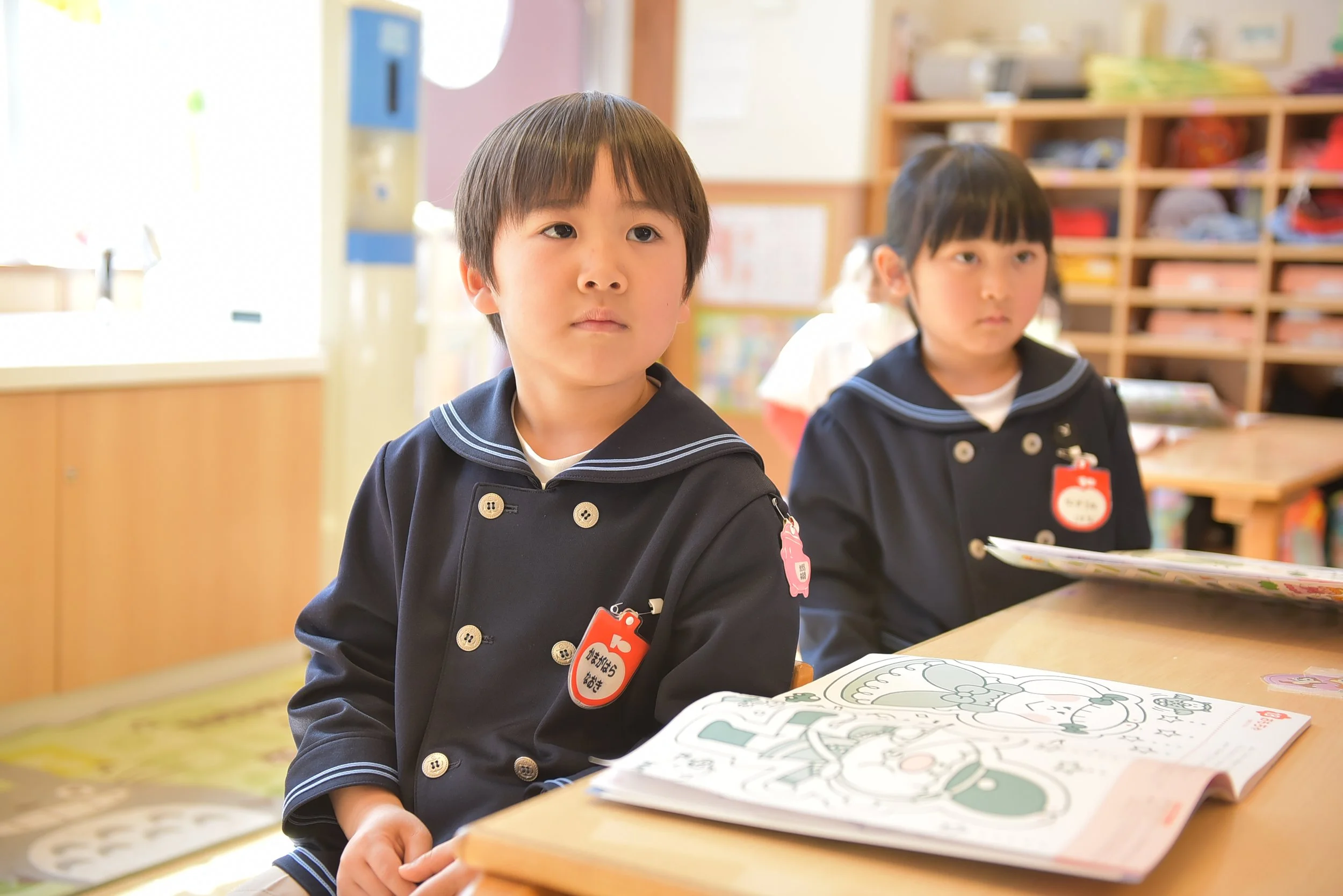 制服を着た子どもたちが教室で授業を受けている様子