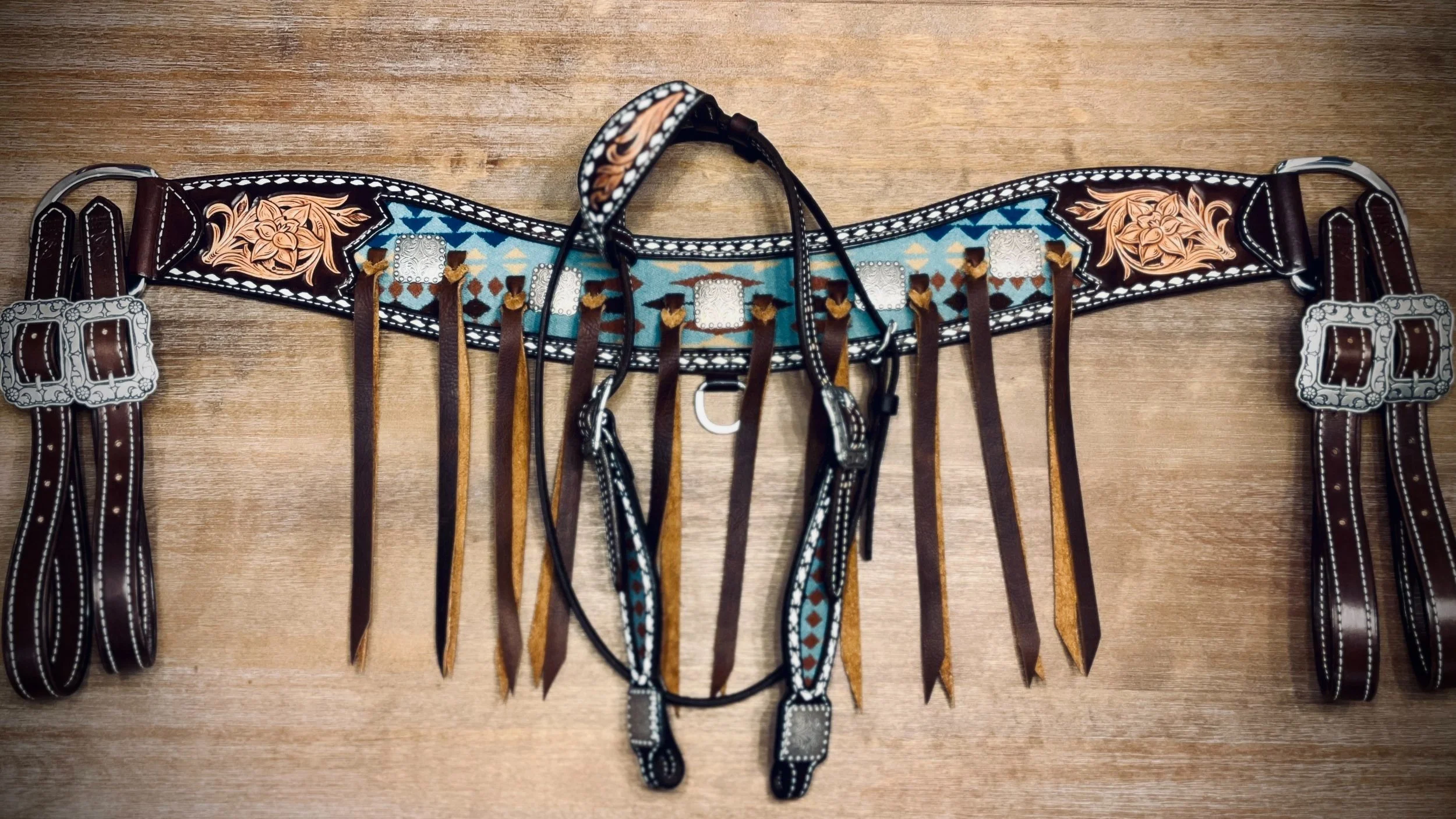 Custom one ear headstall and tripping breast collar with Pendleton wool inlay, floral tooling, and white buckstitch on dark Hermann Oak leather and silver hardware.