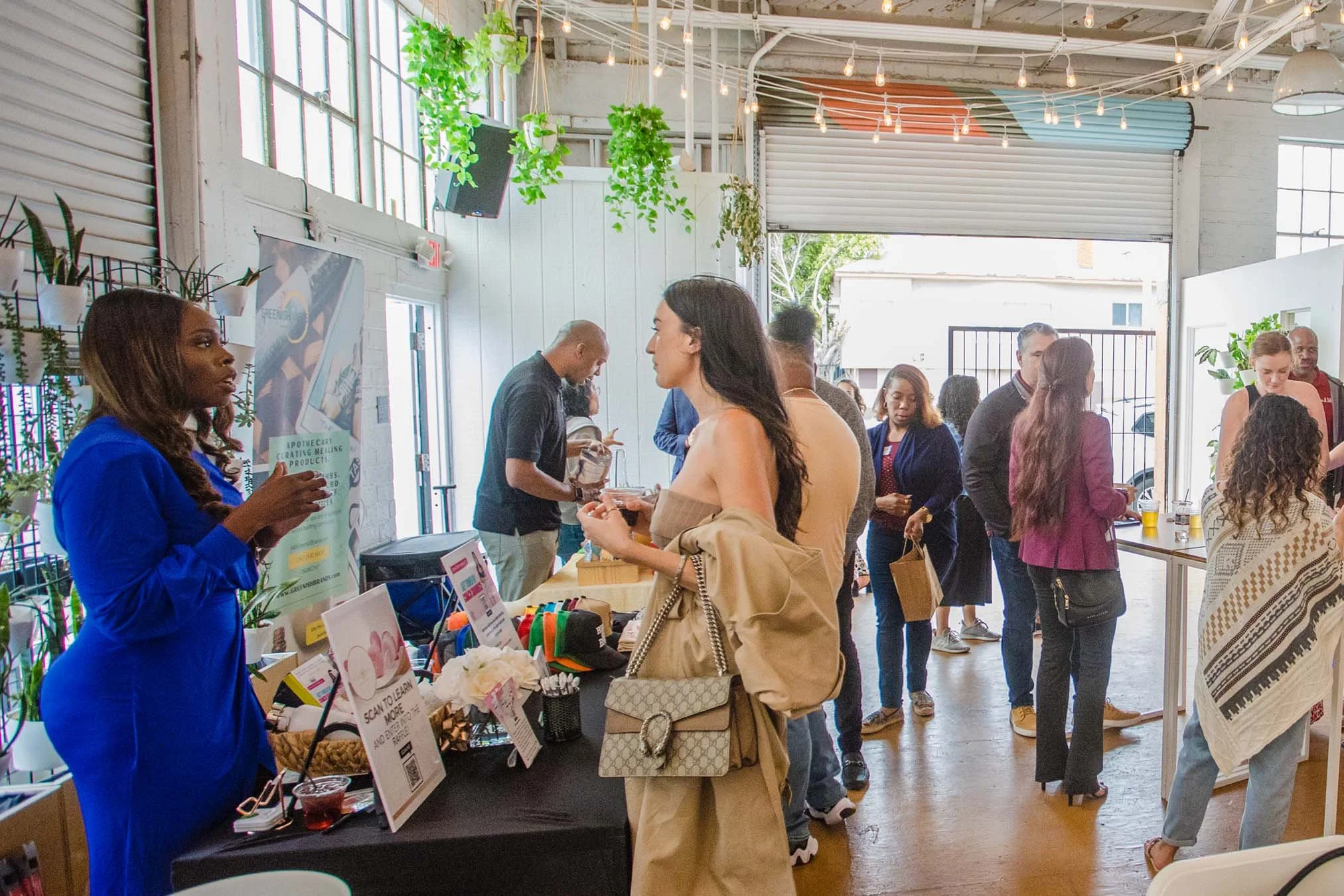 bright-room-full-of-booths-highlighting-impact-lab-small-business-participants-with-mingling-guests-talking.jpg