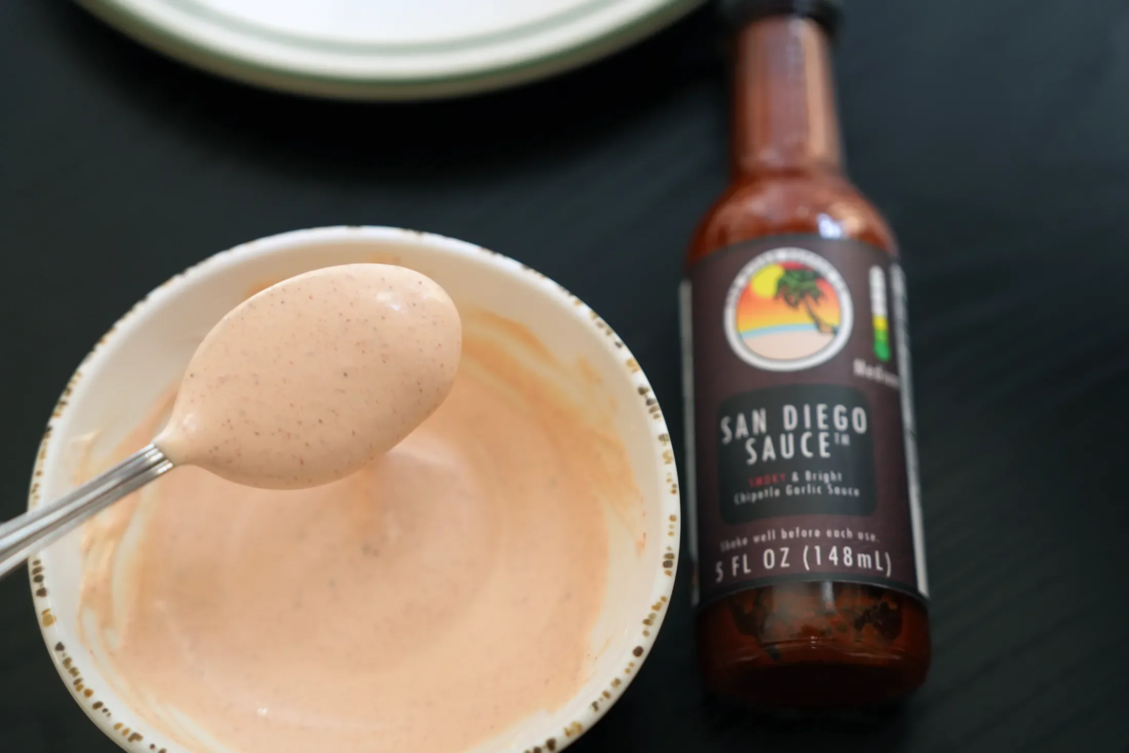 mixing sauce with San Diego Pepper Co hot sauce in it