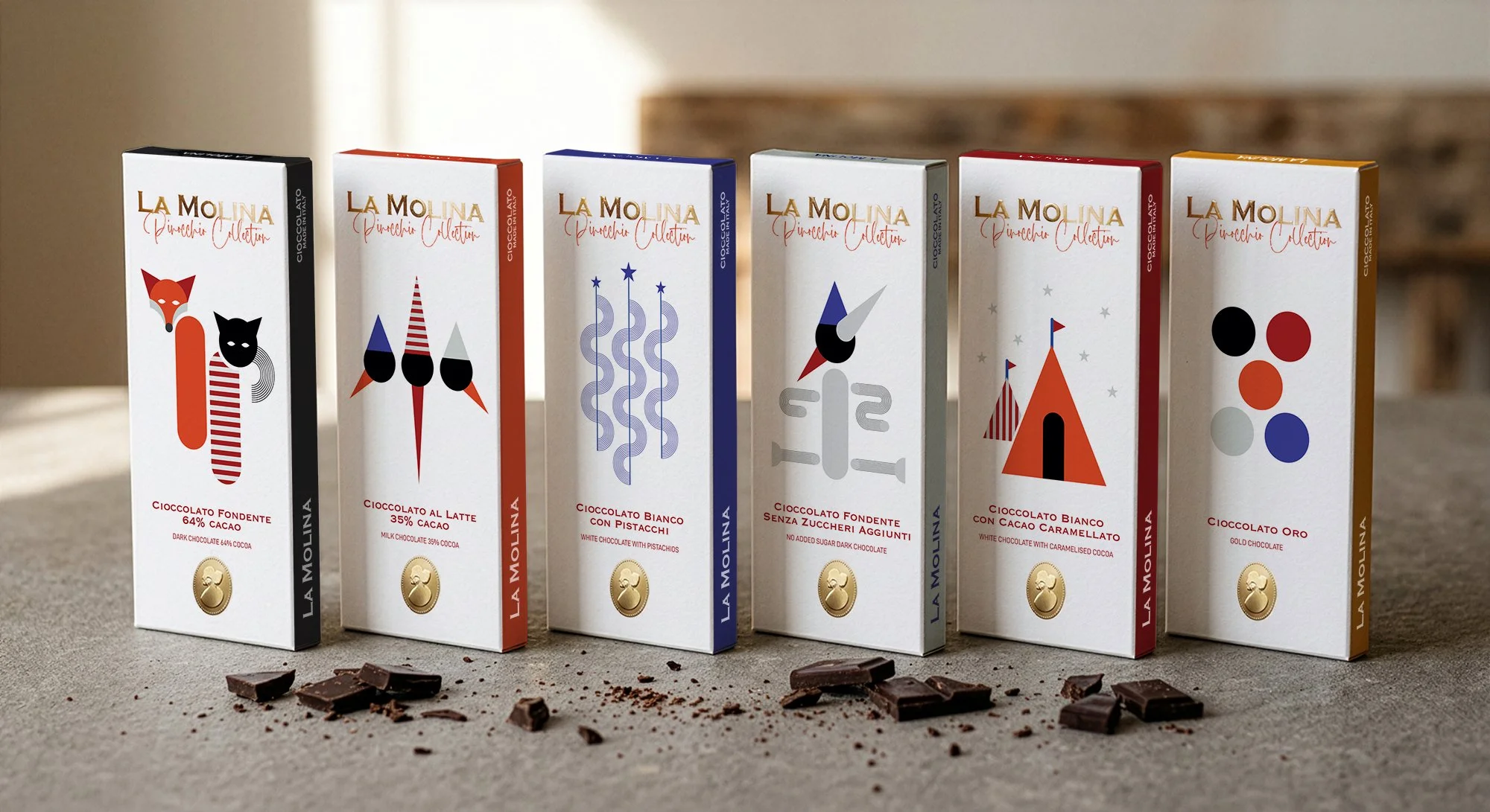 Six boxes of La Molina chocolate lined up on a countertop with small pieces of chocolate and cocoa powder scattered in front. Each box has a colorful, minimalist Pinocchio-themed design and includes text indicating different types of chocolate.