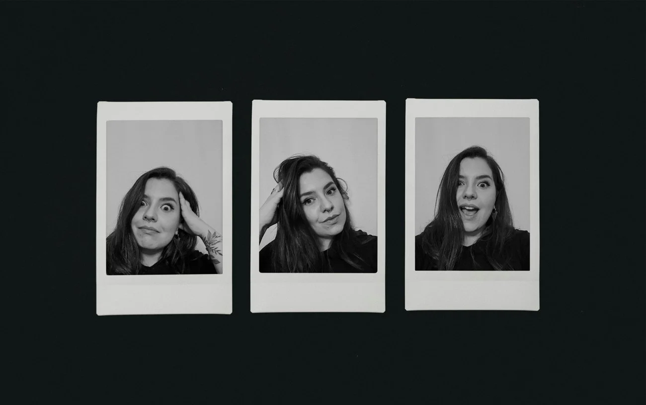 Three black-and-white instant photo prints of a Klaudia, each showing a different facial expression, laid out on a dark surface.