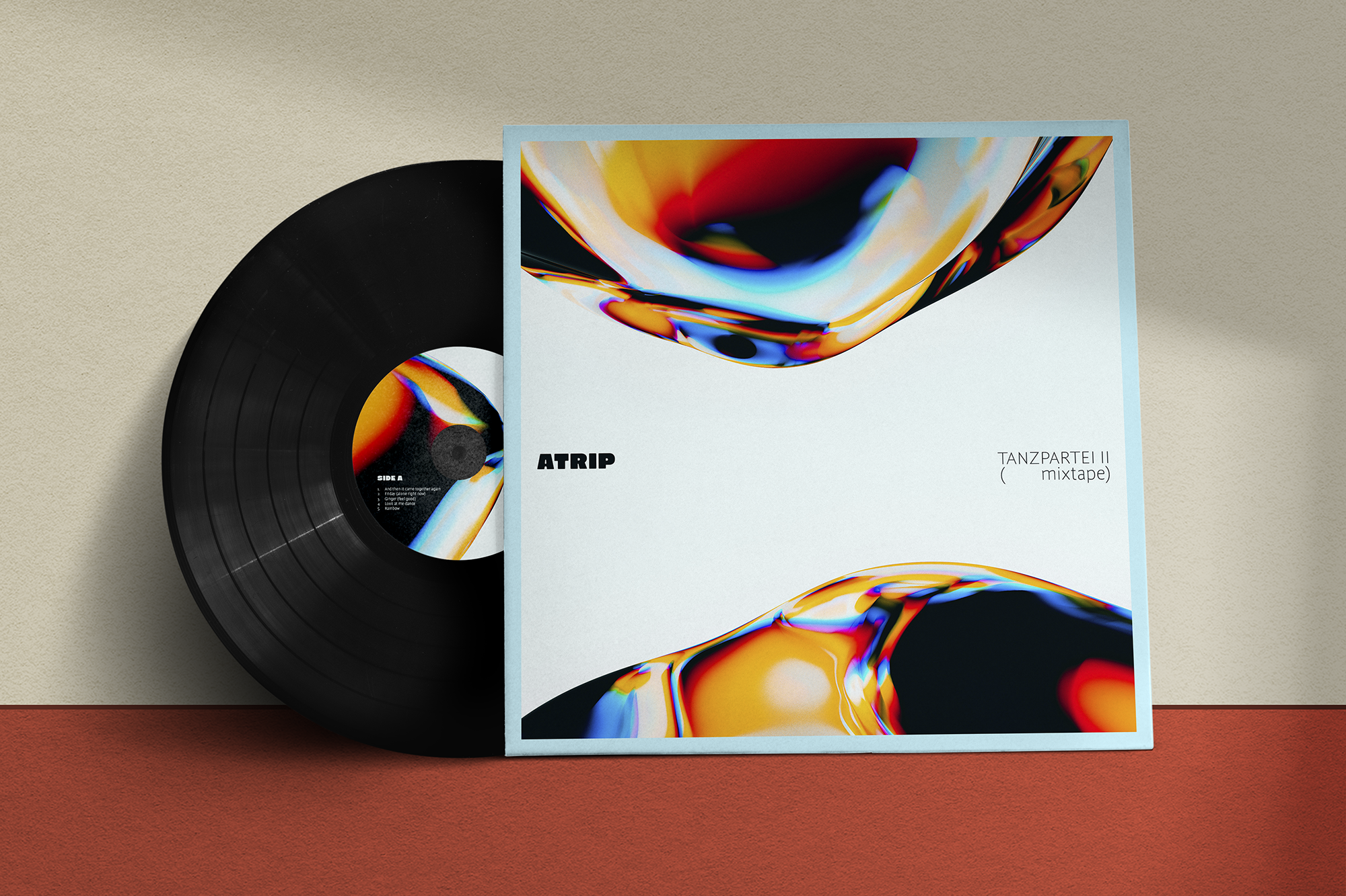 A vinyl record and a framed album cover featuring an abstract, colorful design on a neutral background.