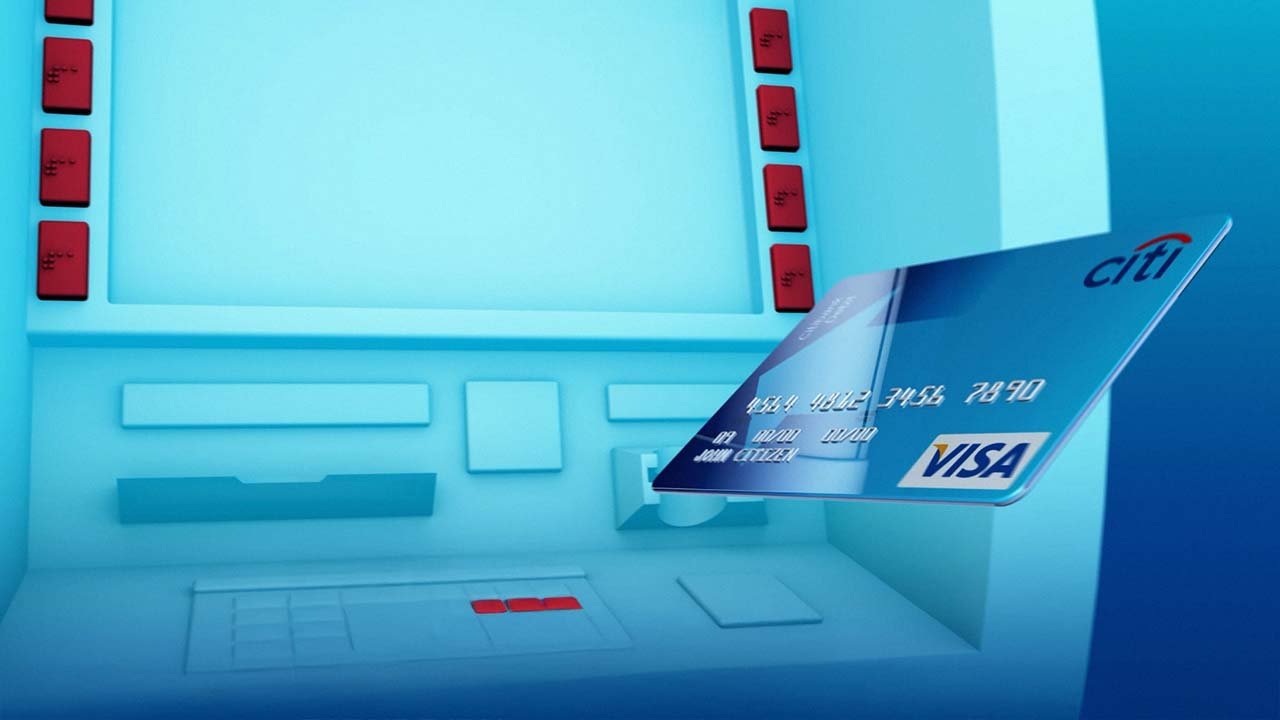 A blue ATM machine with red keys and a partially inserted blue Citi Visa credit card.
