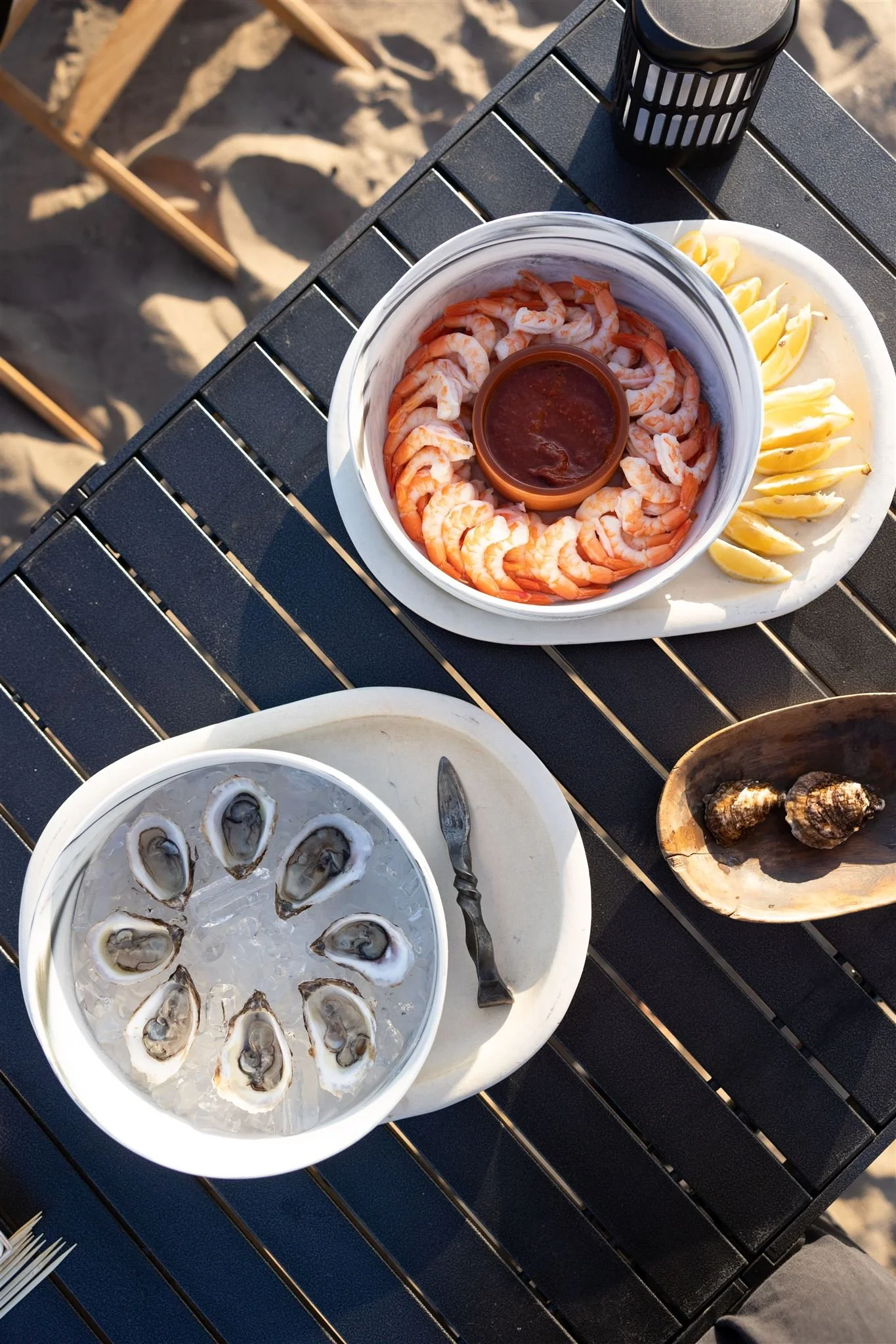 Shrimp cocktail and oysters on camping table at the beach
