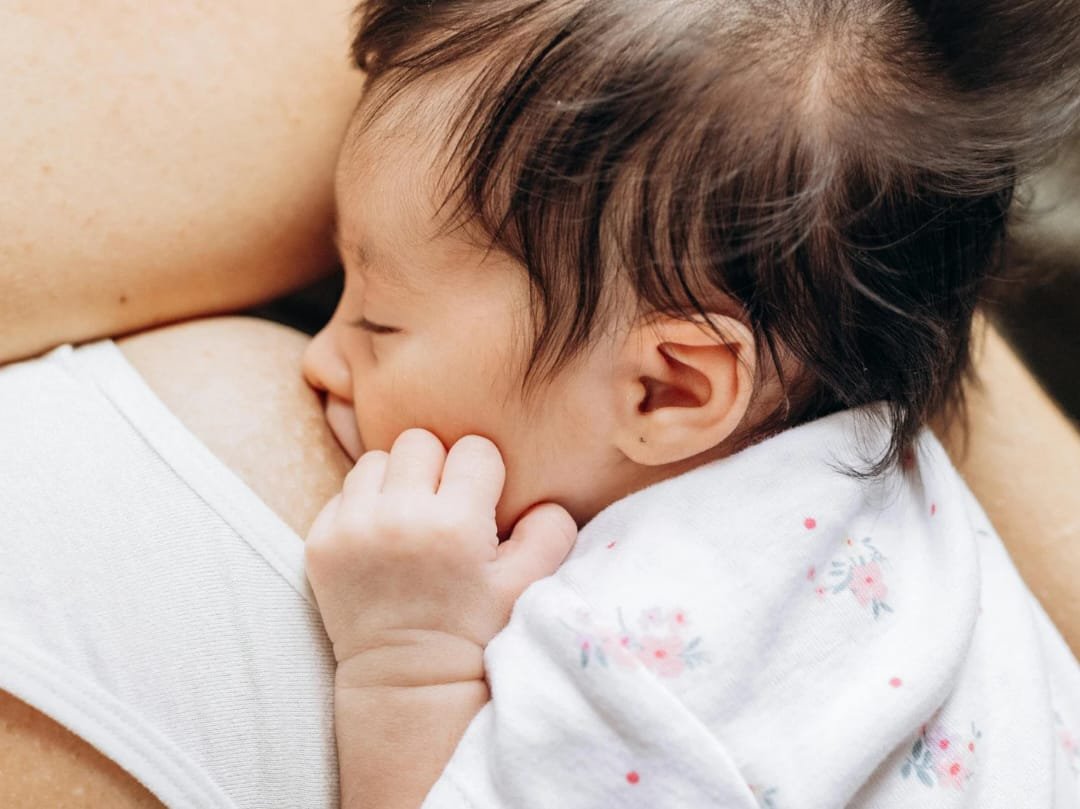 Bambina che fa il nido con la madre mentre si riposa.