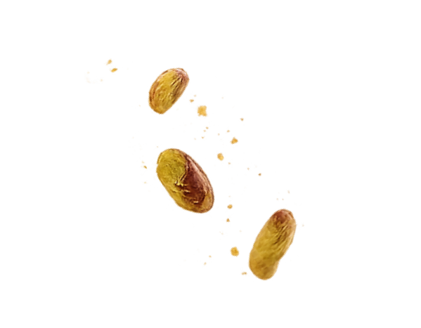 Three pistachio nuts, some with shells and some without, with ground pistachio pieces scattered around.