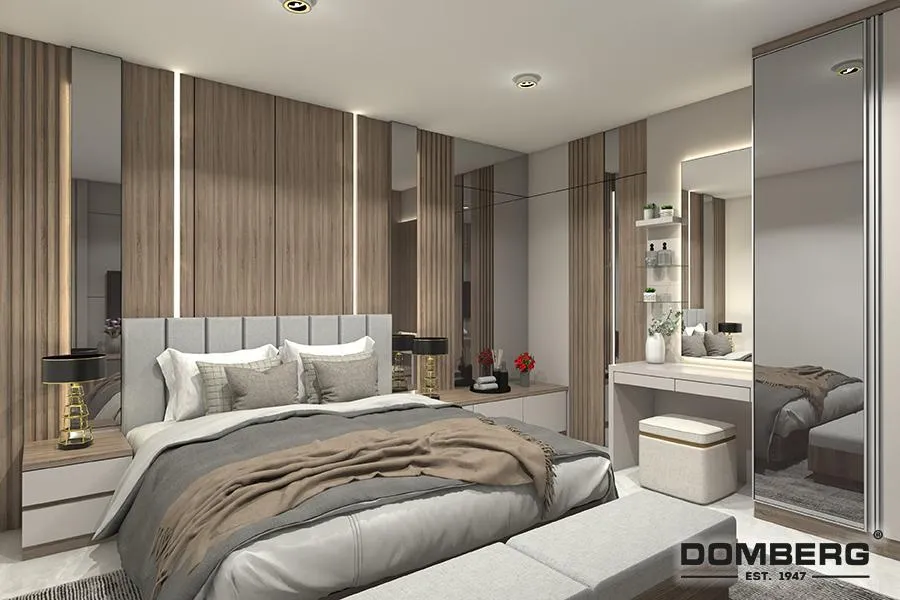 Modern bedroom with a large bed, beige and gray bedding, wooden wall panels behind the bed, mirrored closet, and a dressing table with a mirror and stool.