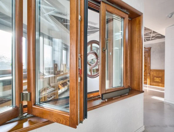 Wooden framed sliding glass door leading to an enclosed balcony or sunroom with a view of interior rooms.