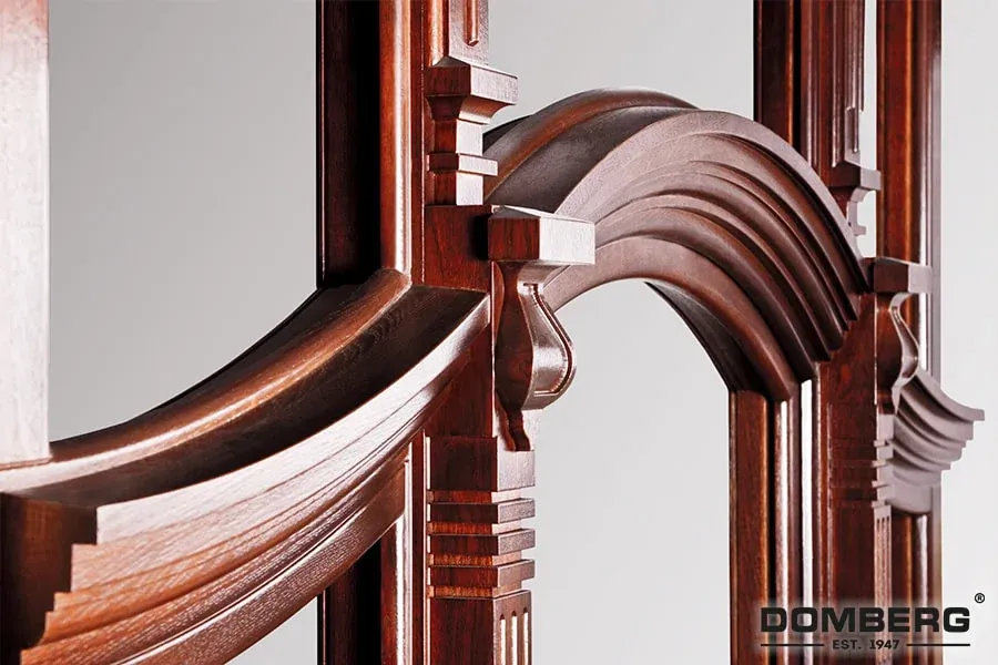 Close-up of a detailed, polished wooden architectural frame with curved and rectangular decorative elements.