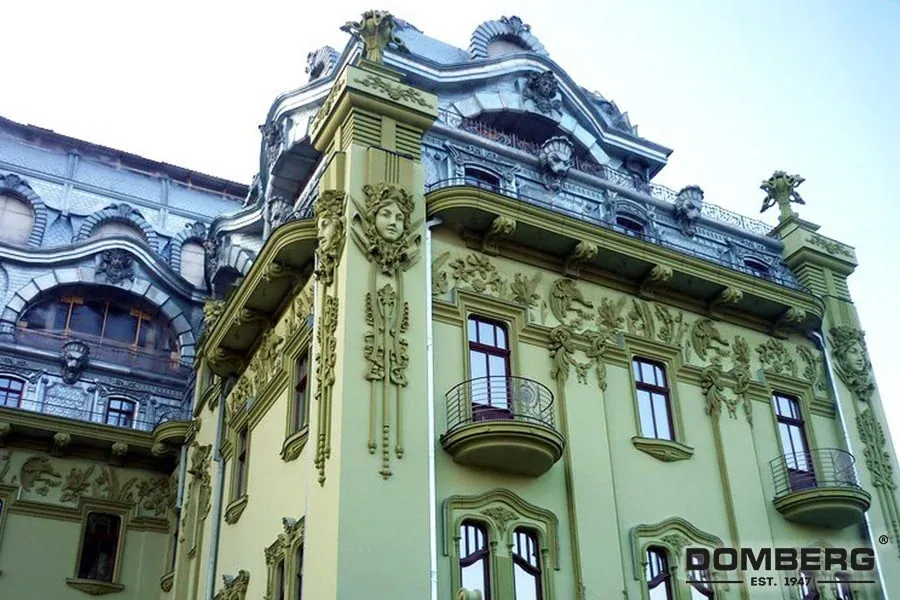 An ornate, historic building with intricate architectural details and decorative sculptures on a pale green facade.