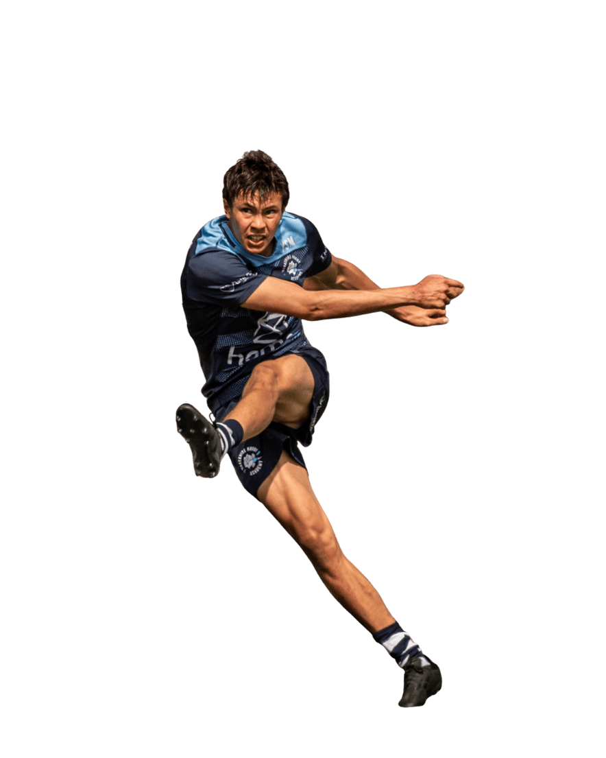 An athlete in a blue and black sports uniform is jumping mid-air with a facial expression of determination or effort. His right leg is extended forward while his arms are positioned for balance.