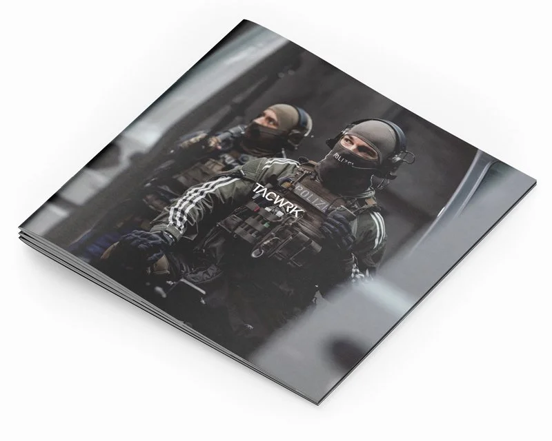 Polizeibeamte in taktischer Ausrüstung stehen in einer urbanen Umgebung.