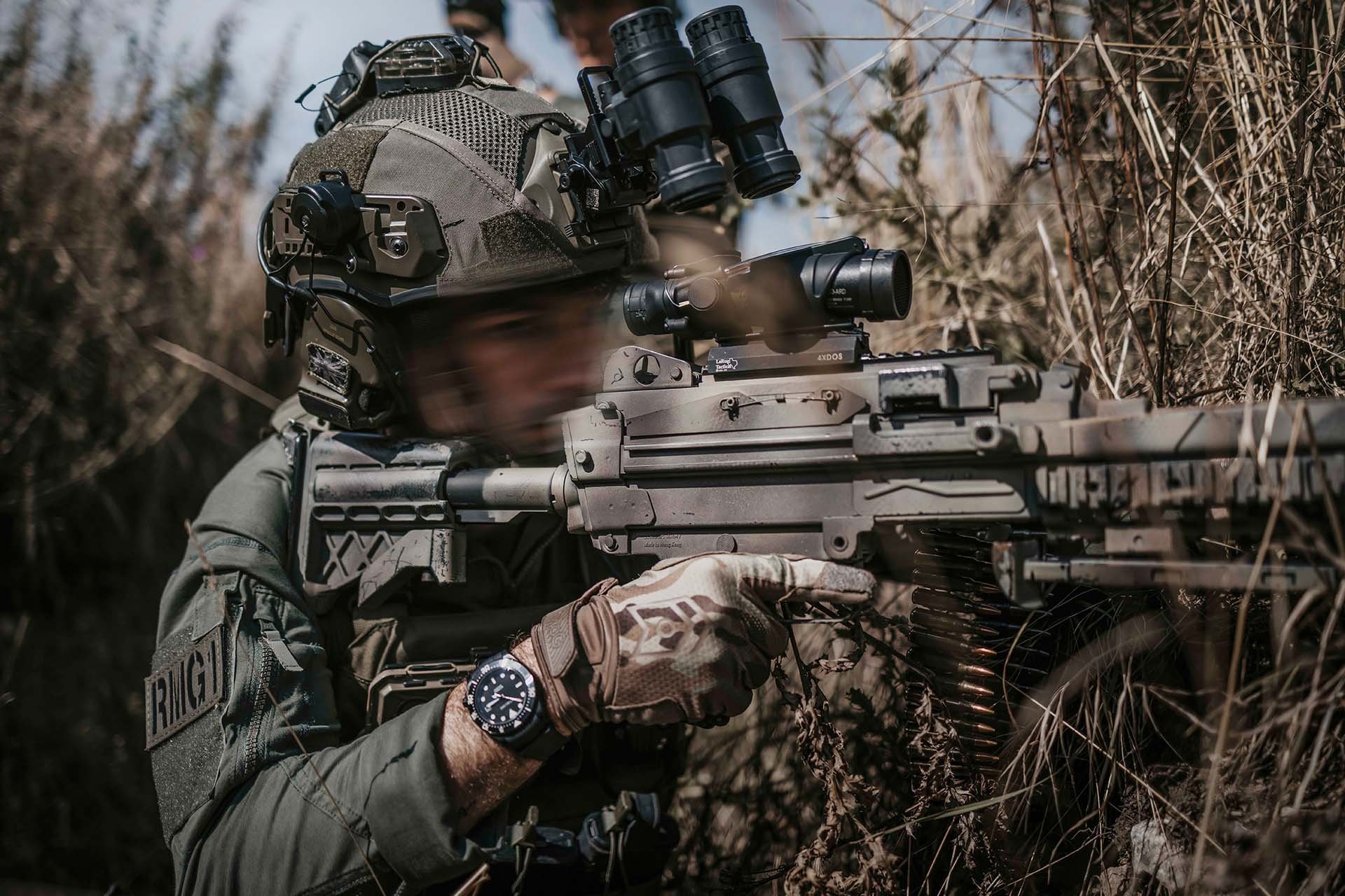 Soldat mit Masters of Gloves Einsatzhandschuhen zielt mit Maschinengewehr.