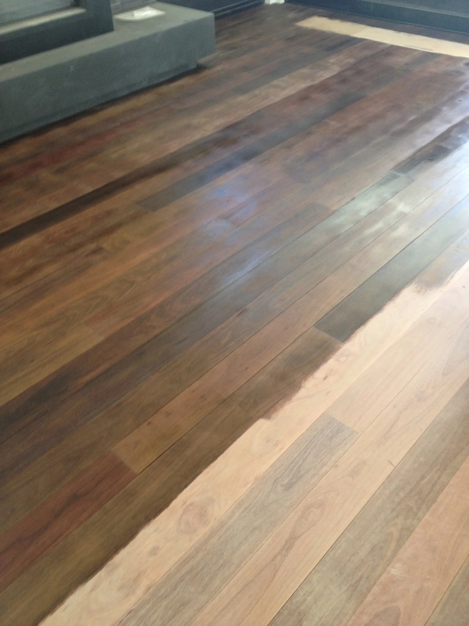 Mixed wood flooring with darker and lighter wood planks in a room.