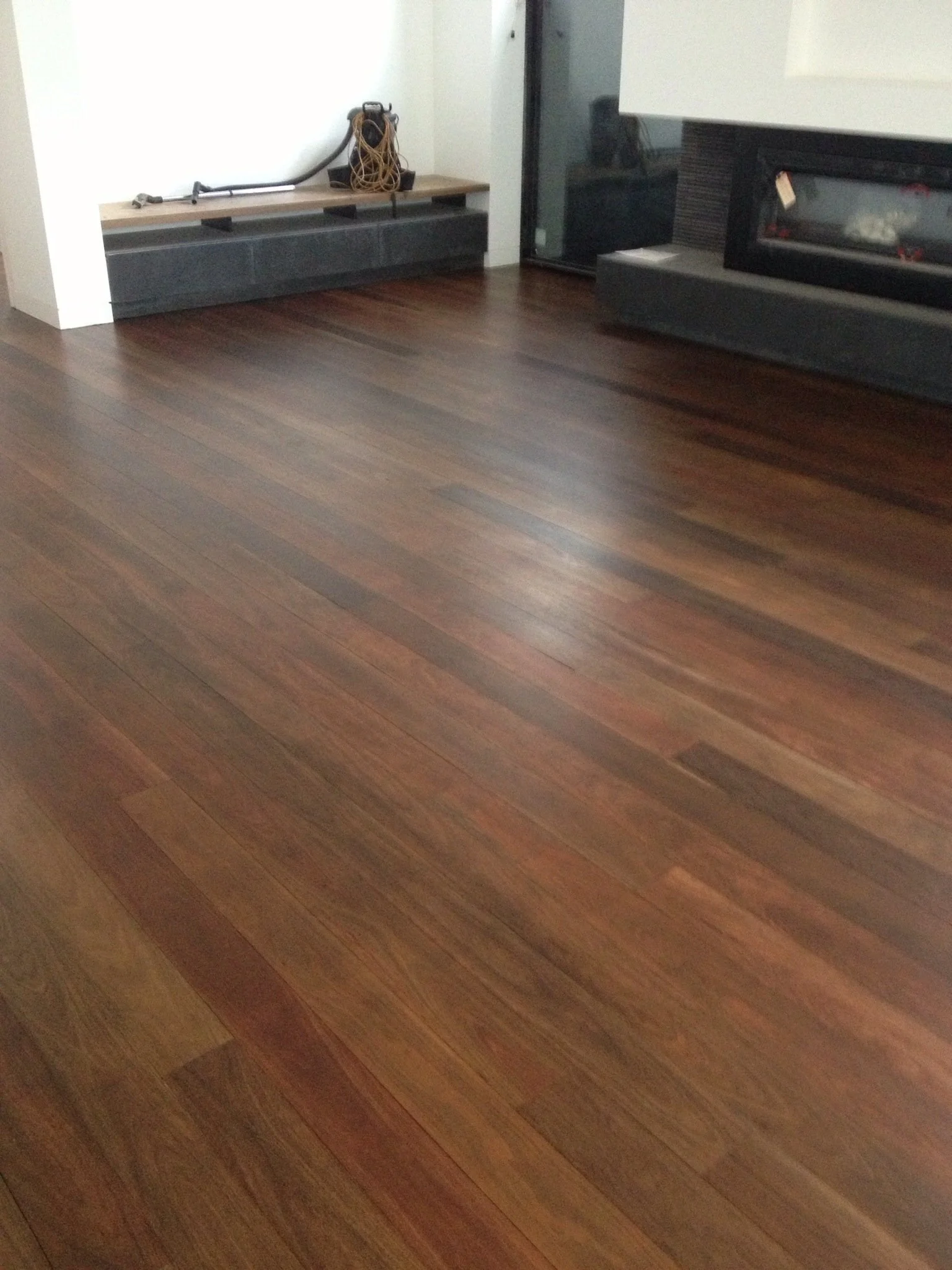 Room with polished hardwood floor and a fireplace on the wall.