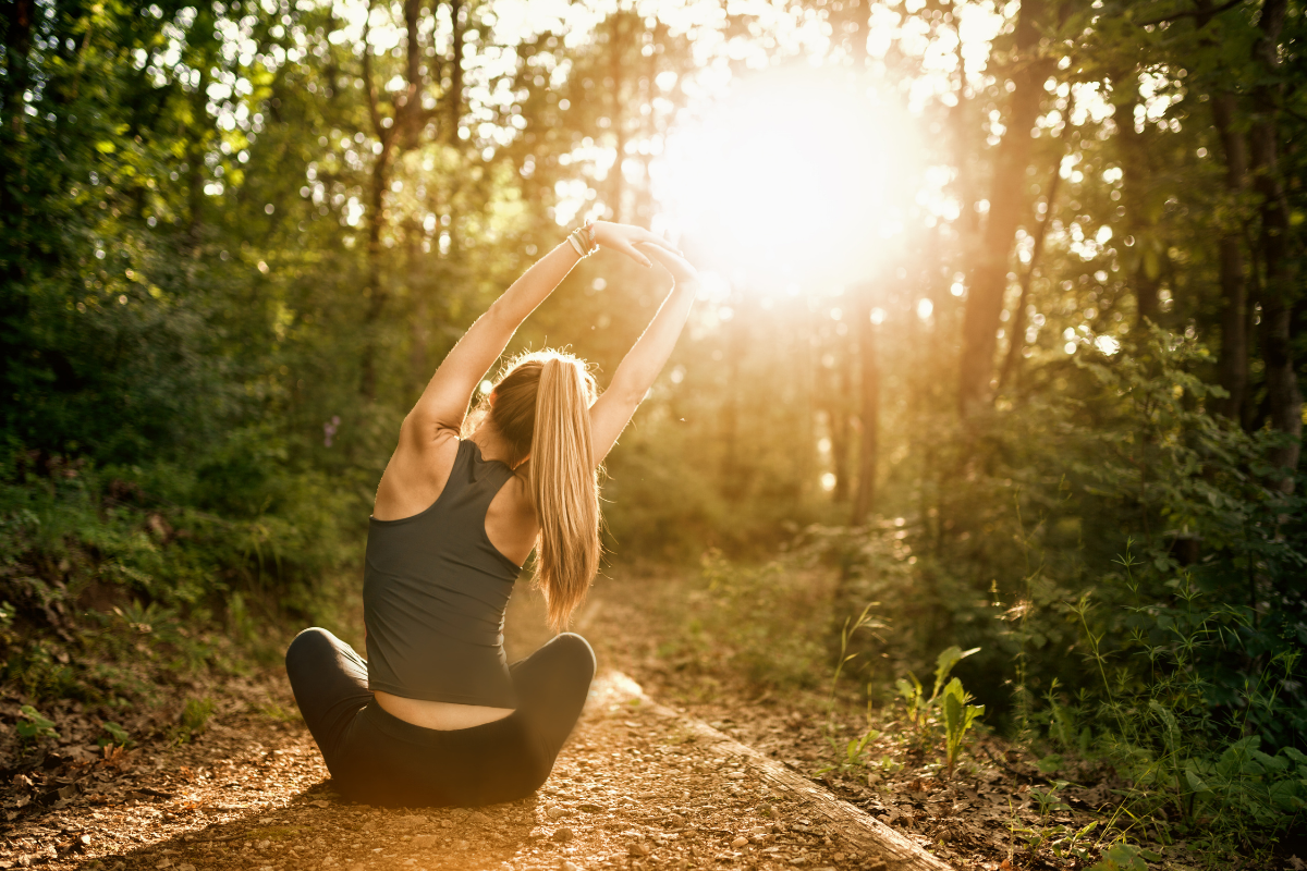 femme en pleine nature faisant des étirements au soleil pour retrouver énergie et vitalité