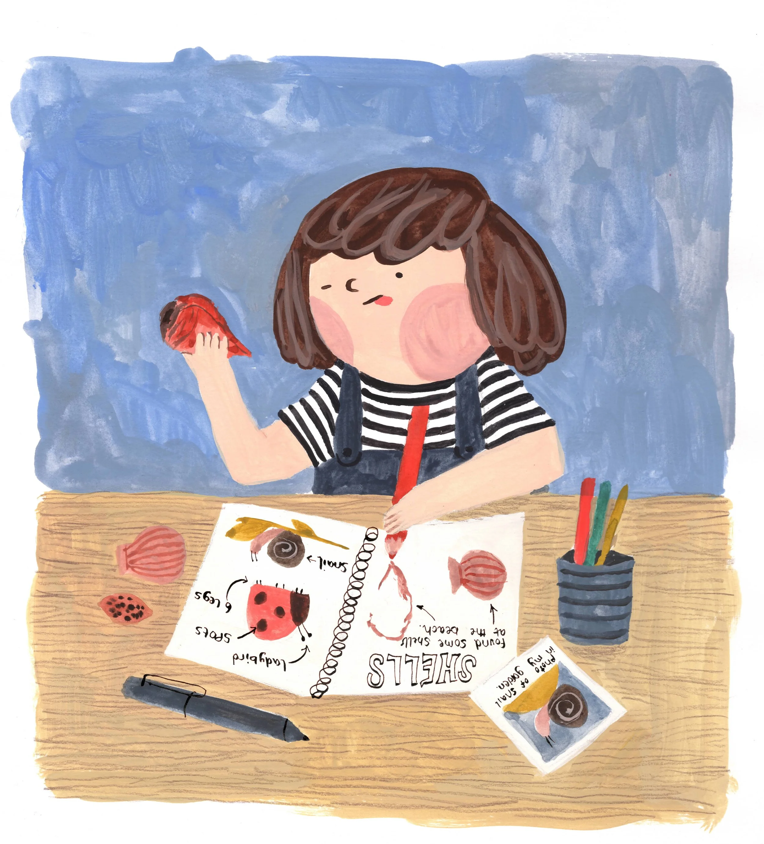 A young girl with brown hair and pink cheeks sits at a wooden table, drawing a shell in her sketchbook. She holds a red crayon in her right hand and a pink shell in her left hand. The table has art supplies including a black marker, and a container w